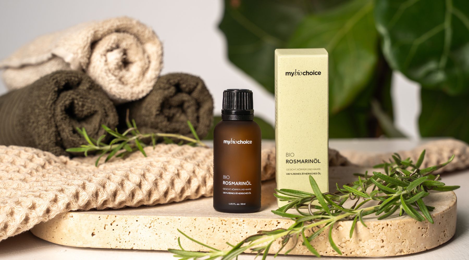 Bio Rosmarinöl von mybiochoice mit Verpackung, Handtüchern und frischem Rosmarin – stilvolles Produktfoto für natürliche Pflege.