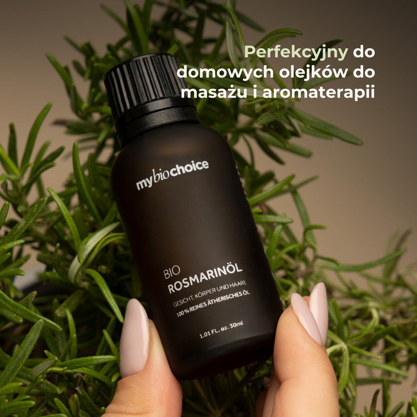 Olejek rozmarynowy mybiochoice 30 ml trzymany w dłoni na tle świeżego rozmarynu.