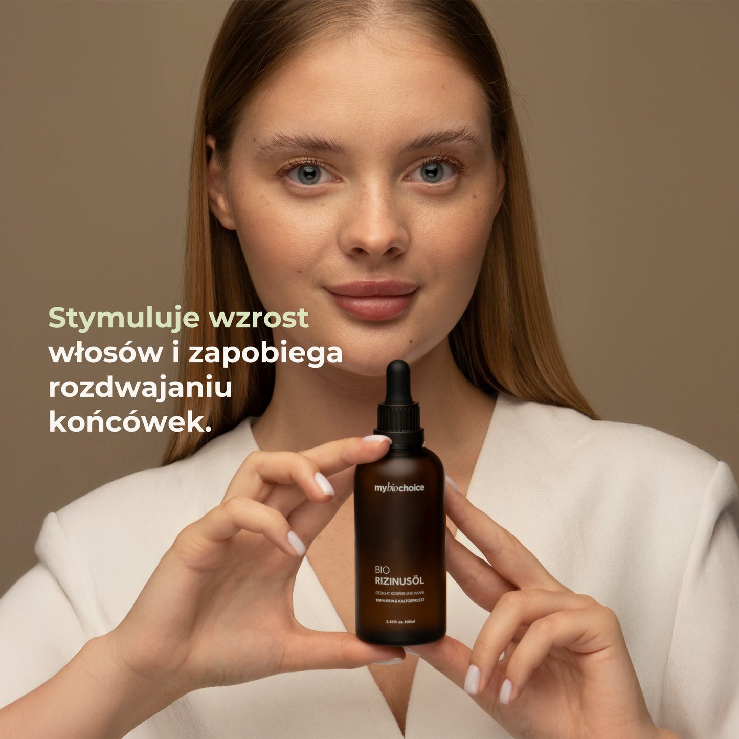 Kobieta trzymająca olejek rycynowy mybiochoice – wspomaga wzrost włosów i chroni końcówki.