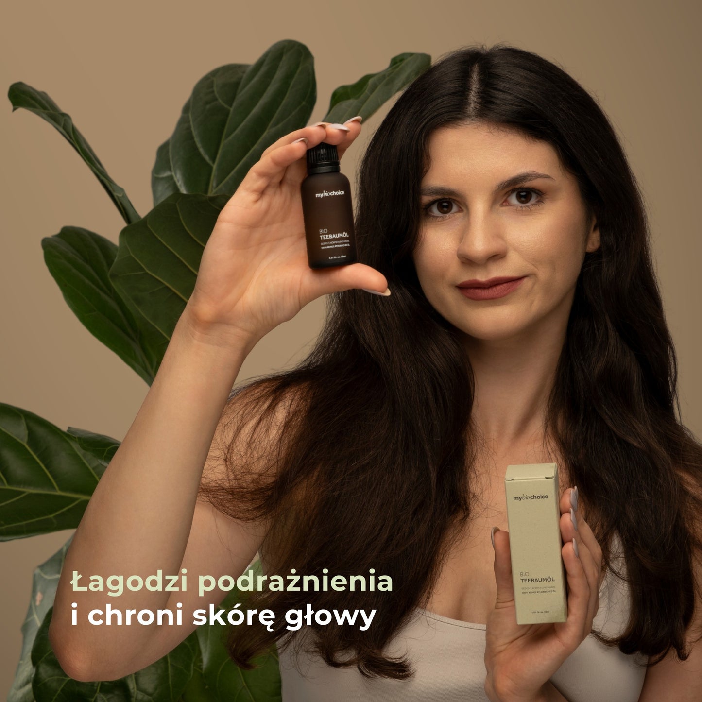 Kobieta trzymająca olejek z drzewa herbacianego mybiochoice — łagodzi podrażnienia i chroni skórę głowy