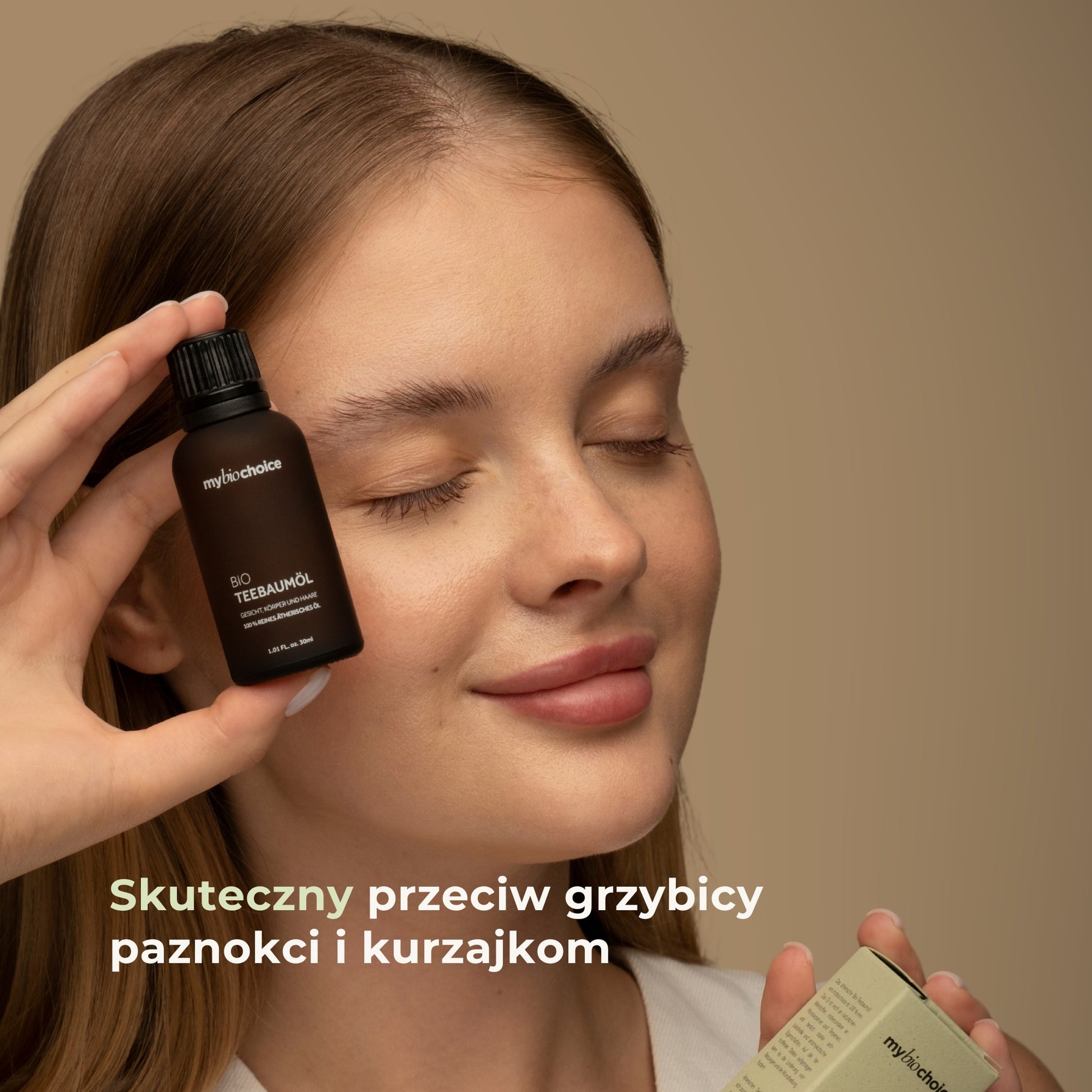 Kobieta trzymająca olejek z drzewa herbacianego mybiochoice — skuteczny przeciw grzybicy i kurzajkom