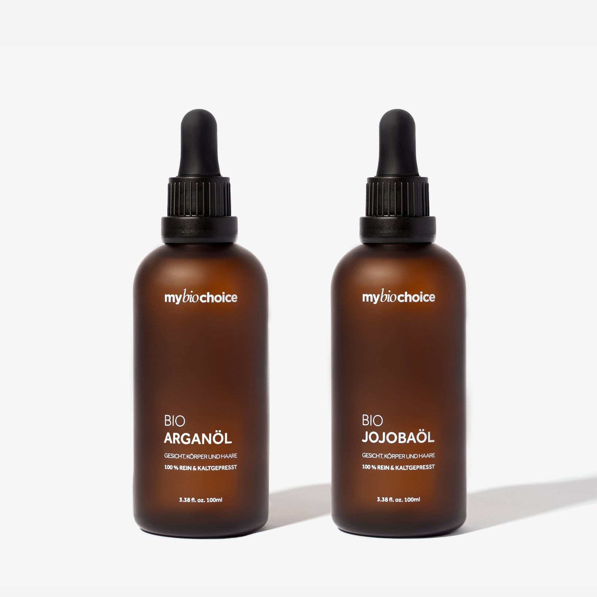 Zestaw bio olejków: arganowy i jojoba mybiochoice w brązowych butelkach do naturalnej pielęgnacji twarzy, ciała i włosów.