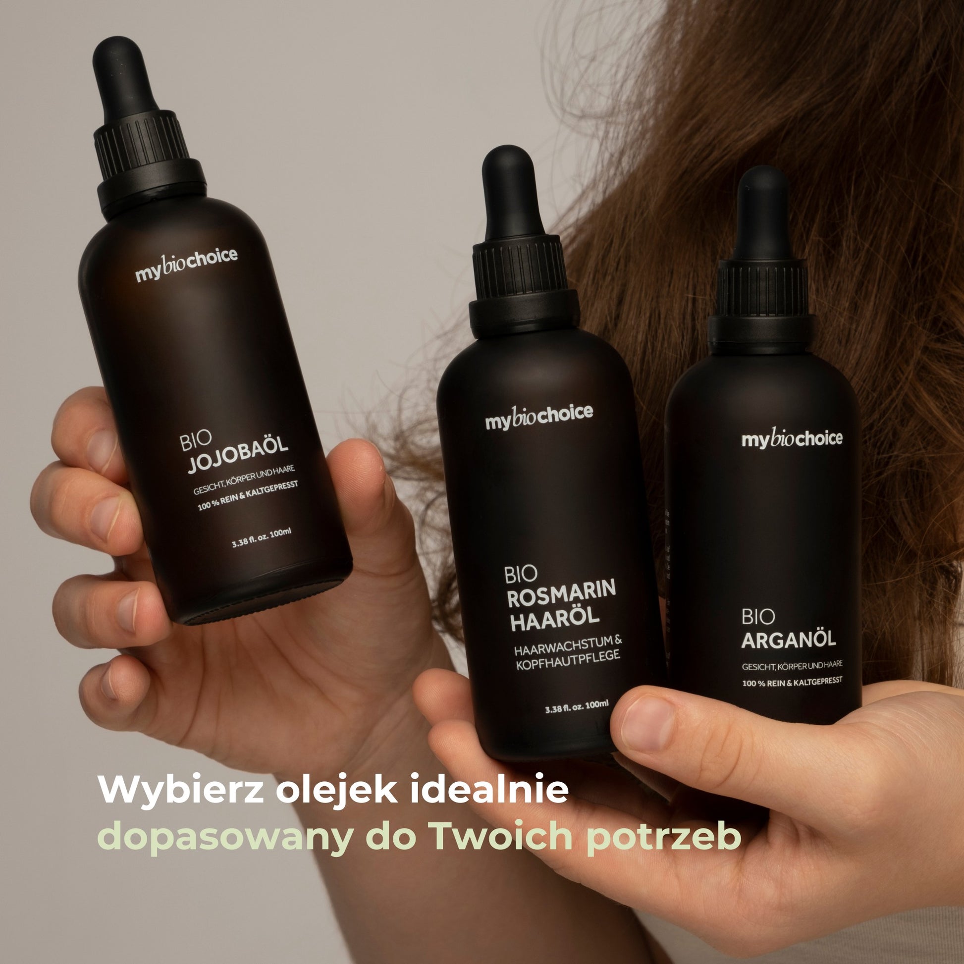 Trzy olejki mybiochoice w dłoniach: jojoba, rozmaryn i arganowy